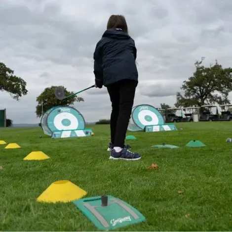 Girl hitting practice golf shots