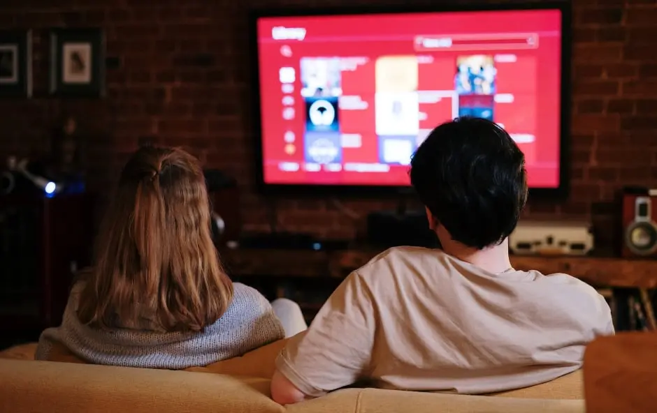 Intec couple sat on sofa watching TV